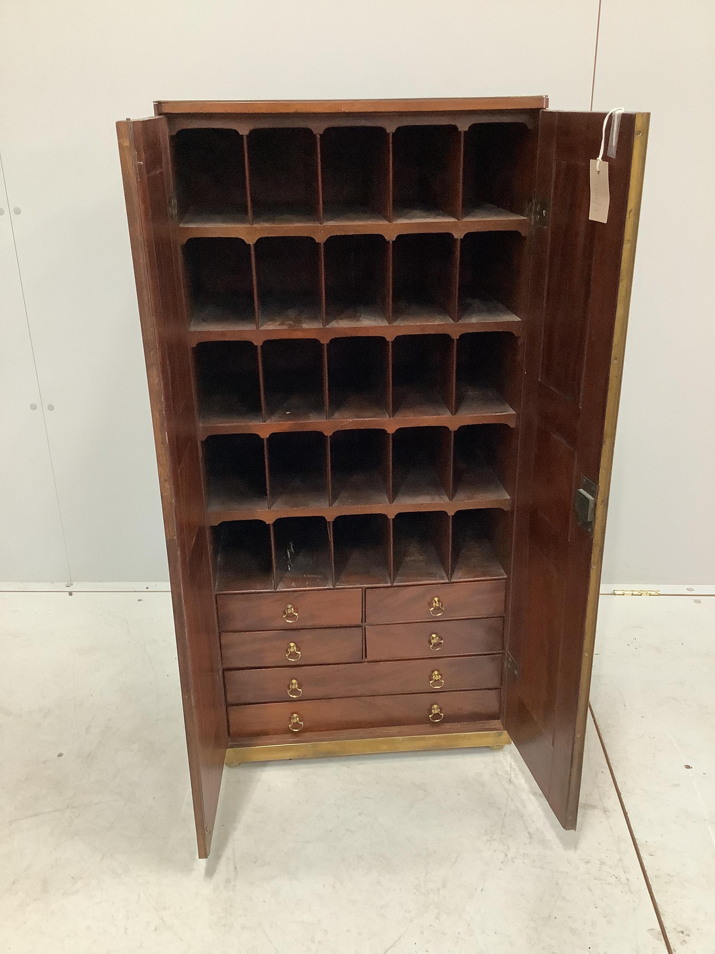 A 19th century brass mounted mahogany pigeonhole cabinet with tapered right side, possibly from a ship, width 53cm, depth 34cm, height 112cm